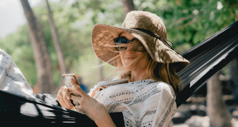 woman in a hammock holding her phone