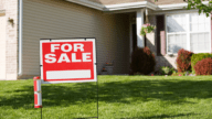 A for sale sign in front of a house that's selling by owner.