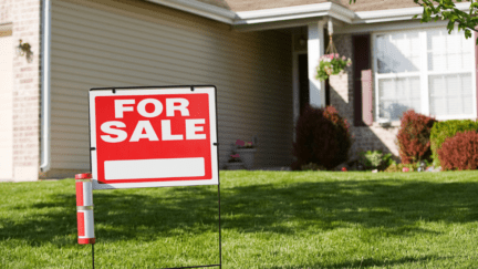 A for sale sign in front of a house that's selling by owner.