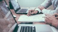 An image of two people working with laptops that represents working with a home investor