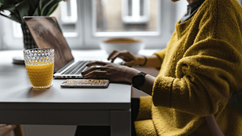 A woman researching capital gains tax brackets on a computer.