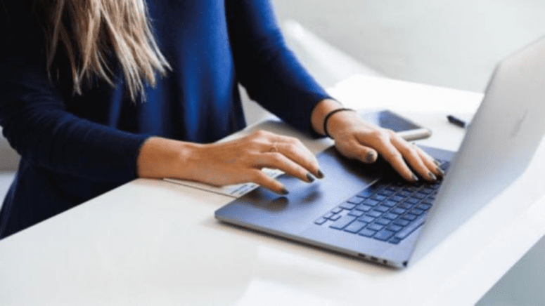 A woman using a computer to determine how much a comparative market analysis cost.