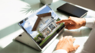 Close-up of a hand checking house on laptop