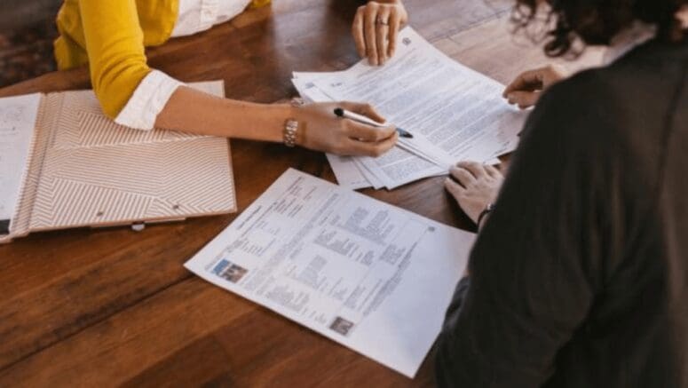 A realtor and client looking at a contract to buy an as is house.