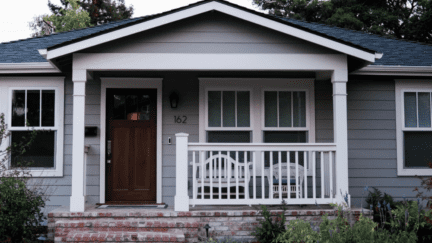 An image of a home with a front porch to suggest selling a rental property.