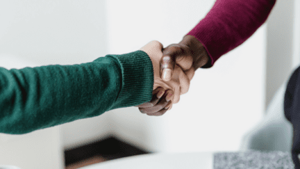 An image of hands shaking to convey how to find a good listing agent.