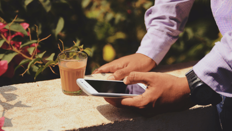 An image of a man using a phone to demonstrate the best house buying apps.