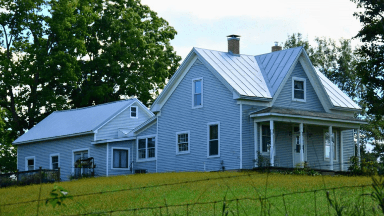 Selling an inherited house in Texas like this older light blue farmhouse on a hill.