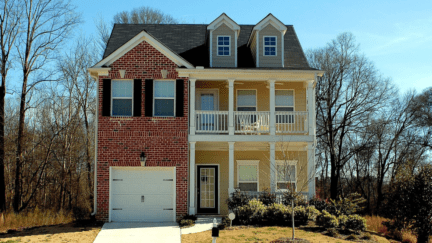 A home that is set to be sold, with the homeowner monitoring property values using a tool like Zestimate.