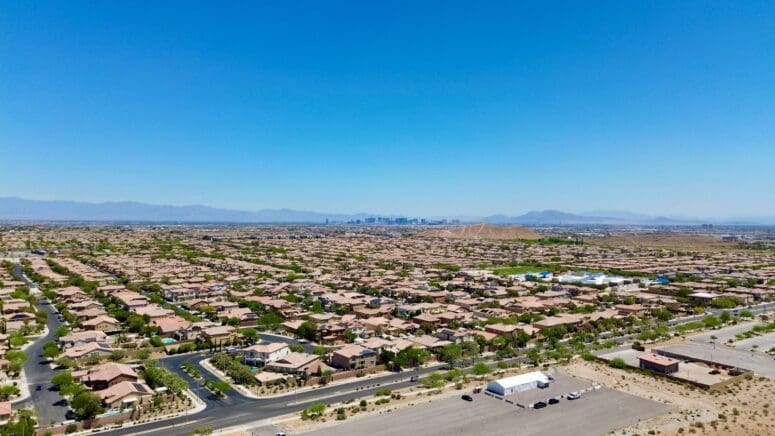 Aerial view of the Las Vegas Strip from a distance, with suburban homes in the foreground.