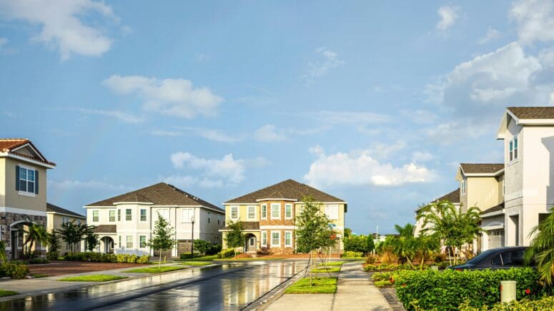 Neighborhood in Orlando, Florida just after a rain shower. The homes are large, two-story residences with stucco and brick or stone exteriors.