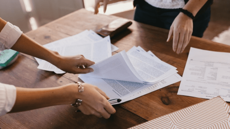 A real estate agent going over paperwork with a seller who is selling a house with no contingencies.