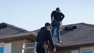 Structural home inspectors on a roof.