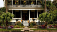 A Louisiana-style two-story house with palm trees around it that could be a fannie mae homepath property.