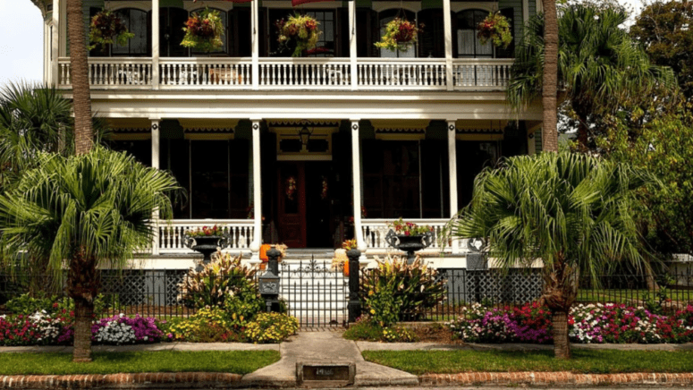 A Louisiana-style two-story house with palm trees around it that could be a fannie mae homepath property.