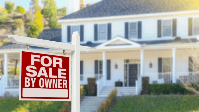 A house with a "For Sale By Owner" sign